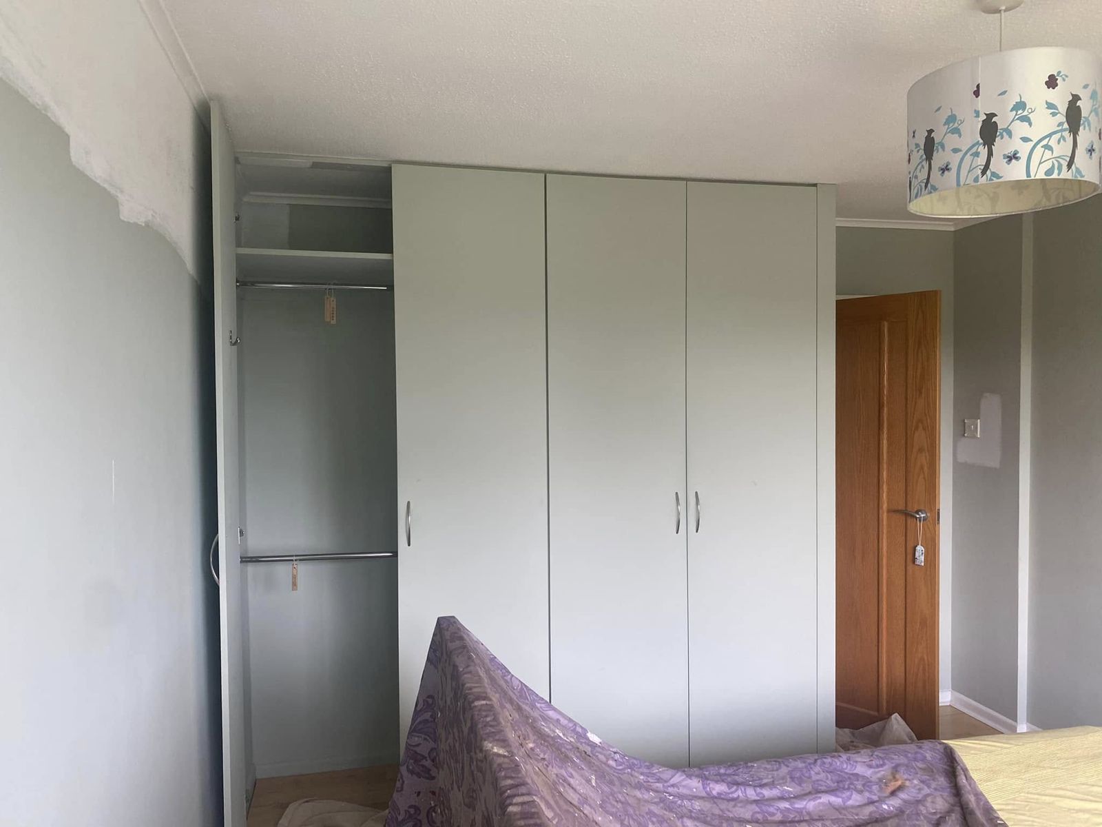 Sage wall beside white fitted wardrobes
