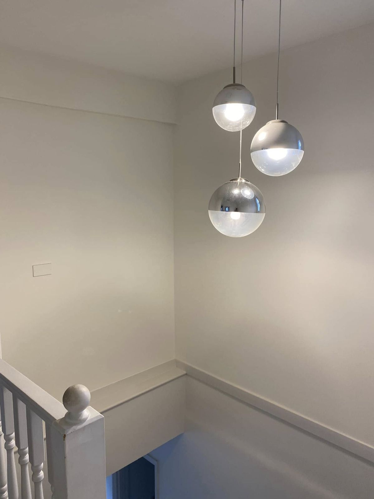 Stairwell with chrome globe pendants and white walls