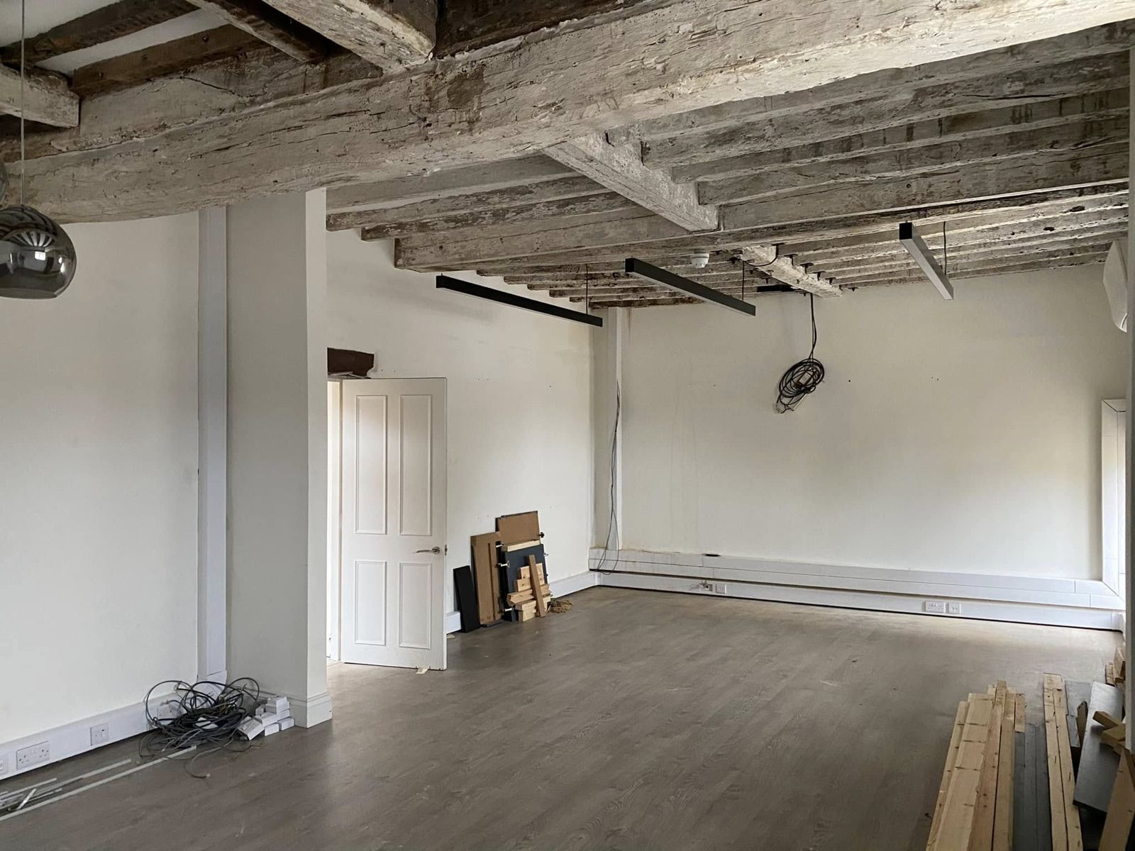 Room with bleached oak ceiling beams and white walls