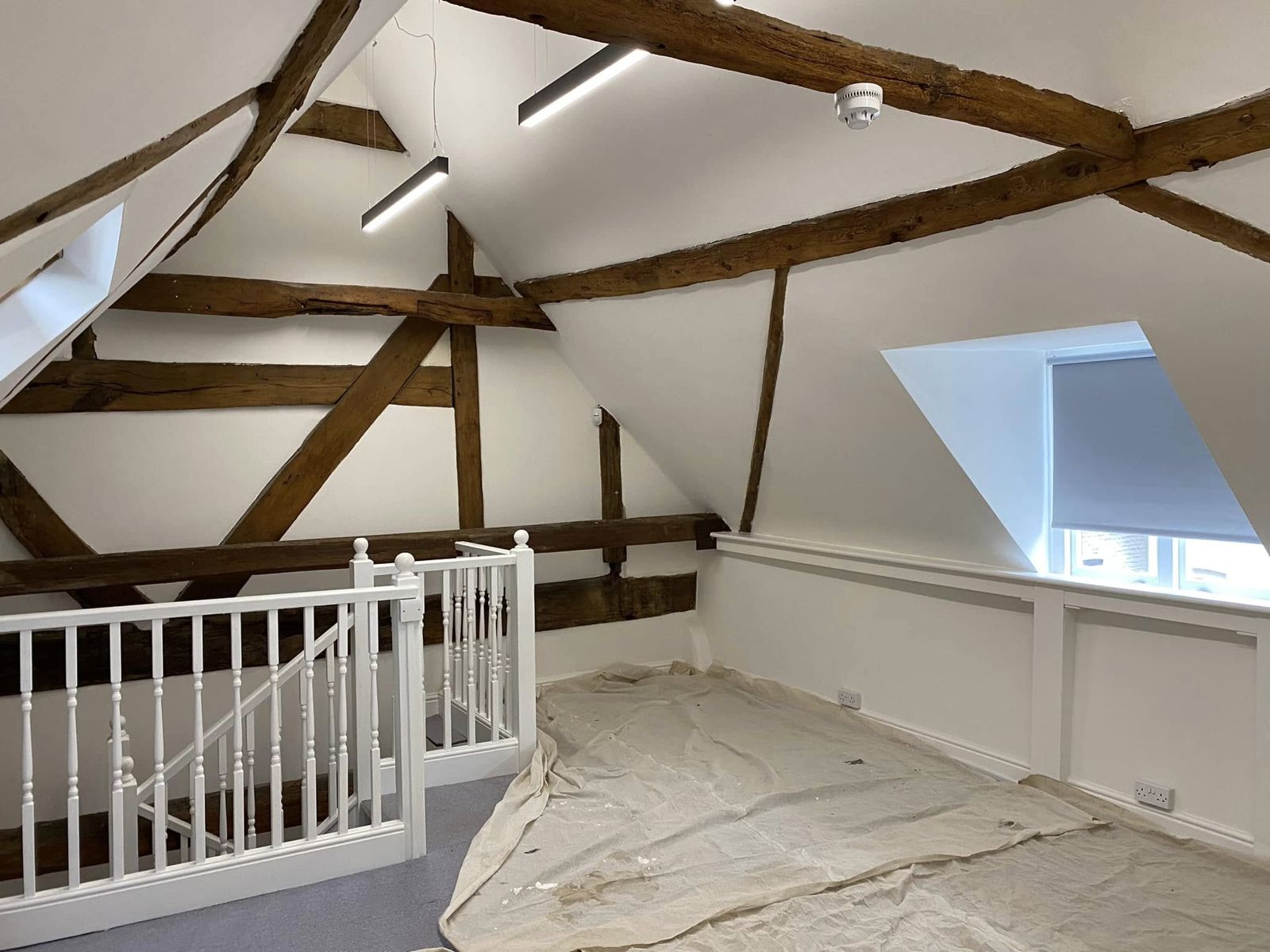 Attic room with oak trusses, a skylight and a white balustrade