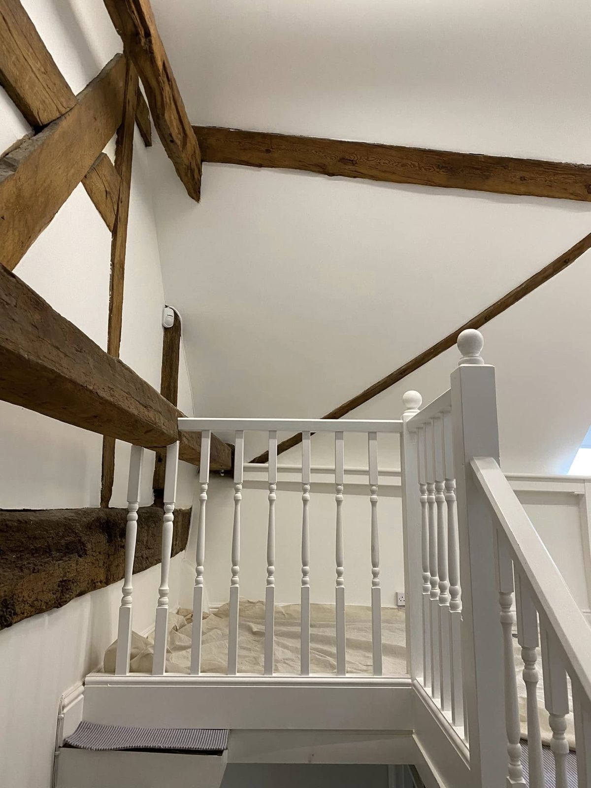 White balustrade rising under oak beams
