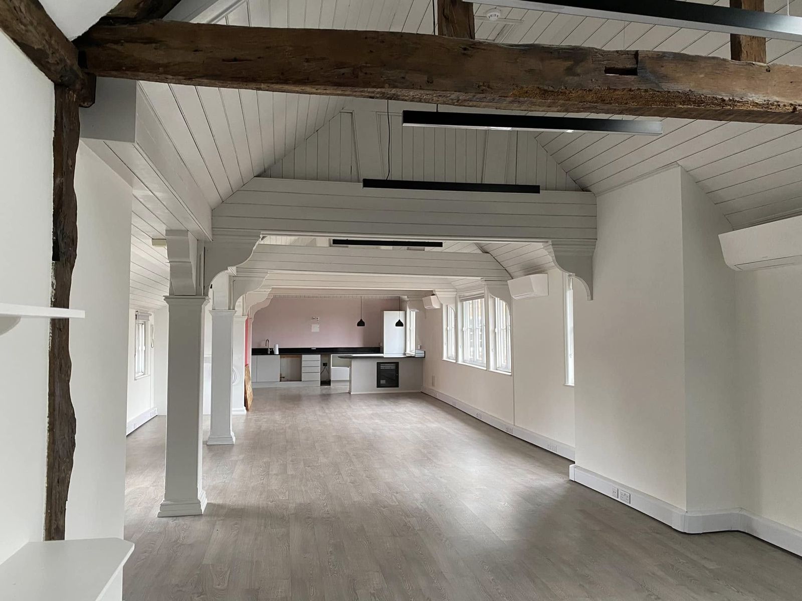 An oak beam framing the long room with the kitchen at the far end