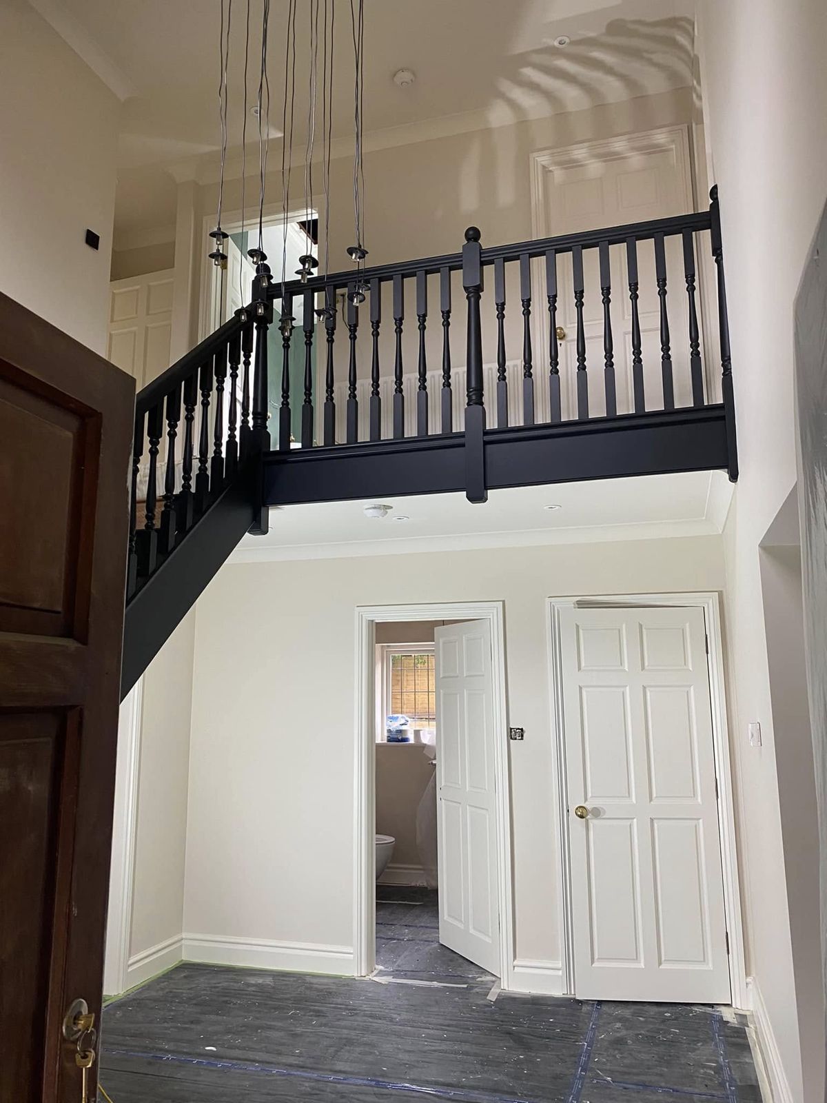 Gallery landing with a charcoal-painted balustrade and white walls