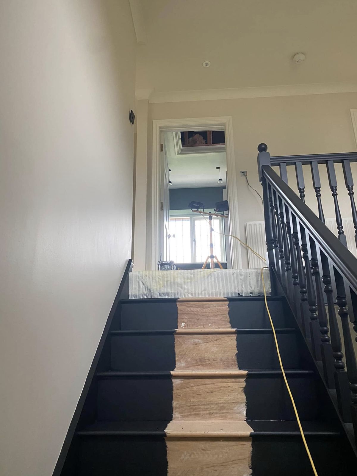 Looking up a charcoal-painted staircase with a stair runner