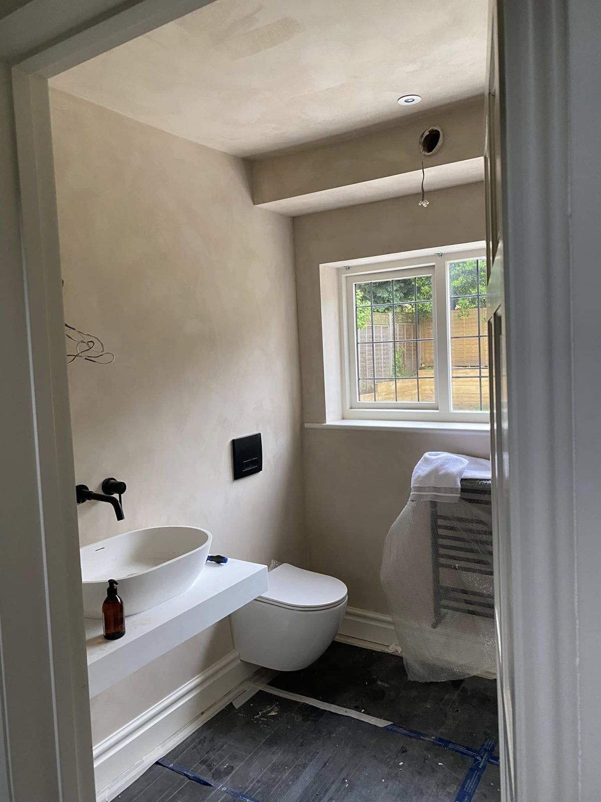 Cloakroom with a white basin and warm plaster-toned walls