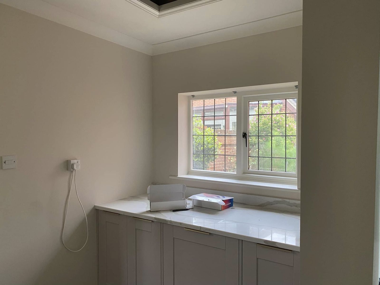 Utility nook with grey units below a leaded window