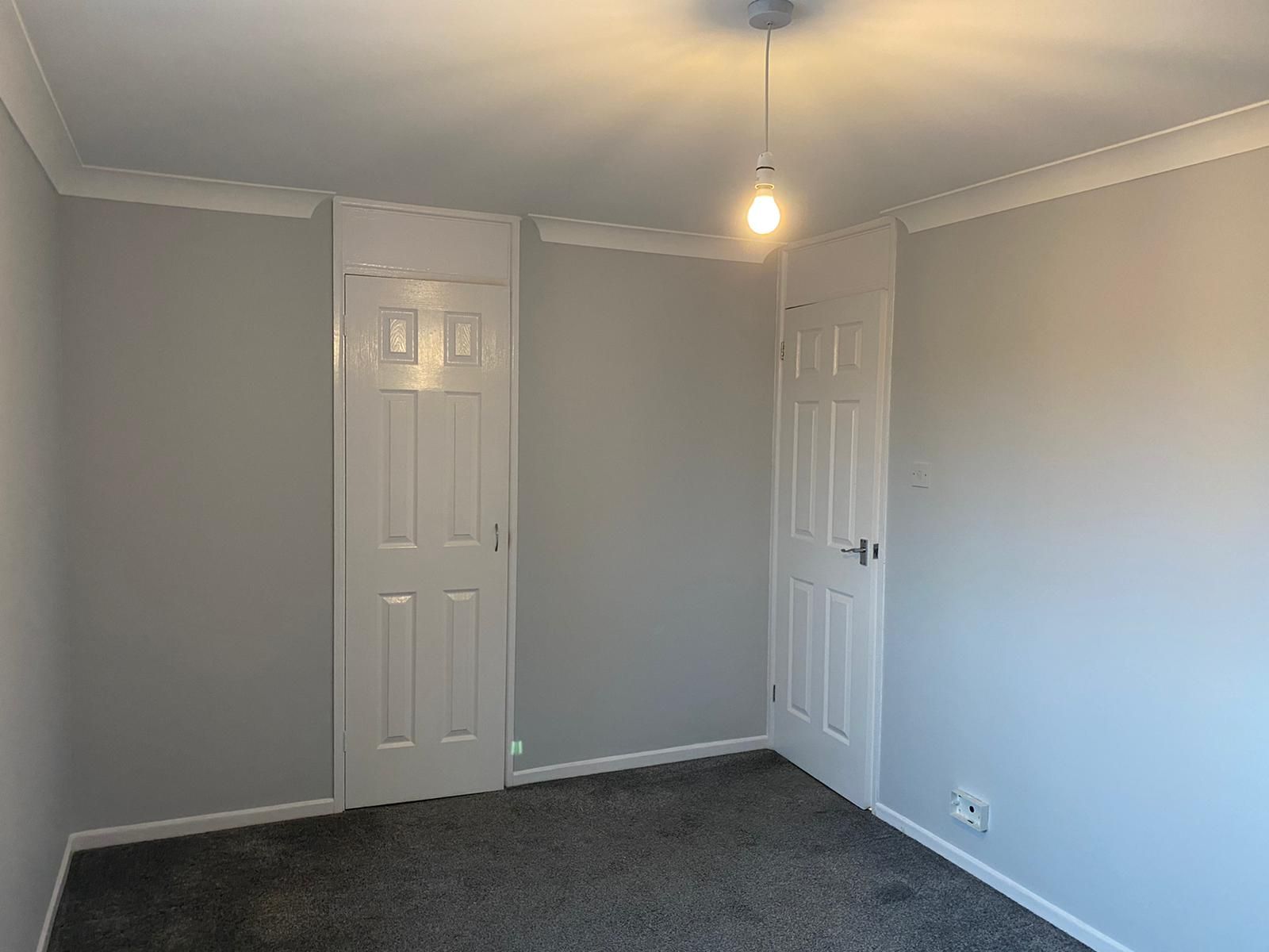 Grey-walled room with white panel doors